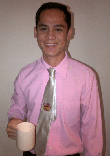 man in pink shirt holding a cup
