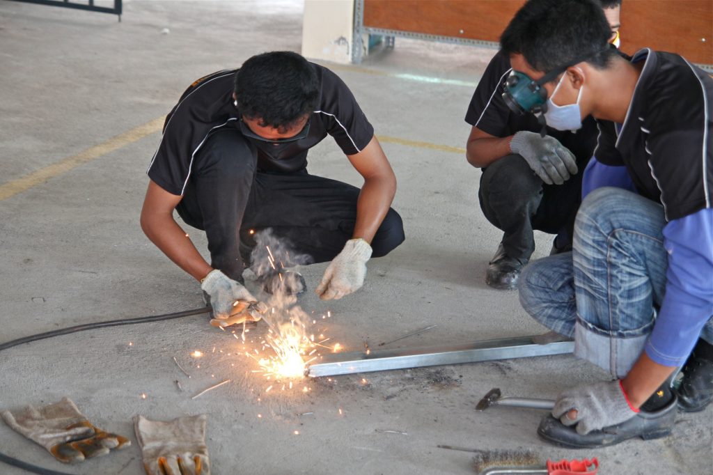 three men welding